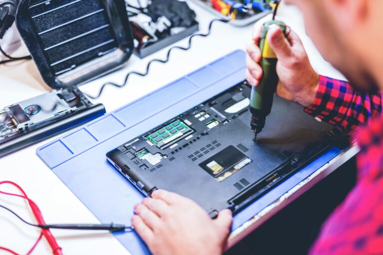 IT engineer technician repairing computer in electronics service shop IT engineer technician repairing computer in electronics service shop