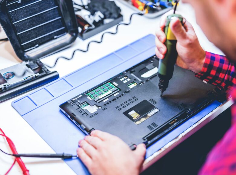 IT engineer technician repairing computer in electronics service shop IT engineer technician repairing computer in electronics service shop