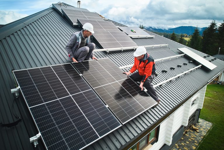 Men workers installing solar panels on roof of house. Men workers installing solar panels on roof of house.