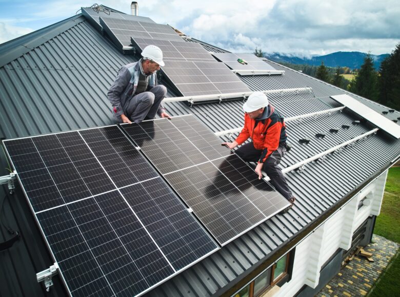 Men workers installing solar panels on roof of house. Men workers installing solar panels on roof of house.